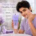 A man in a lavender shirt washes his face with foam while holding a tube of Cosmoflora Advanced Face Wash Gel. The scene is set in a bright bathroom with water splashing, and the left side features promotional text and icons for skin benefits.