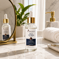 Cosmetica Glow & Anti-Aging Face Serum in a clear glass dropper bottle with a gold collar and white label, set on a marble countertop with a mirror, plant, and white towel in a bright bathroom setting.